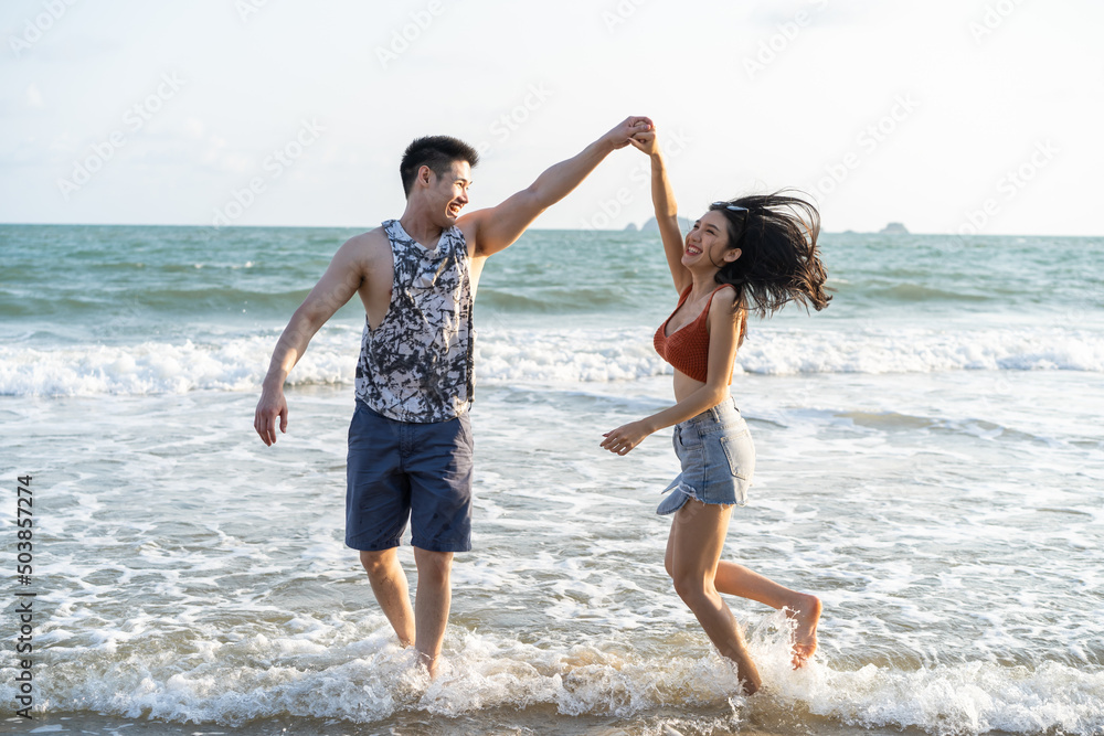 Blurred of Asian young man and woman having fun on the beach together. 