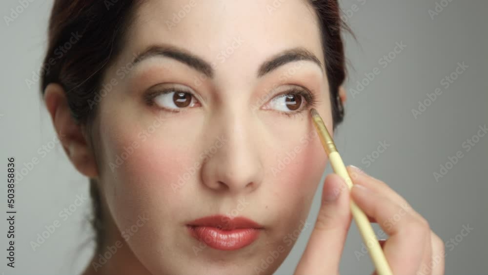 Extreme close on gorgeous brunette Hispanic woman applying eyeshadow Extreme close on gorgeous brunette Hispanic woman applying eyeshadow