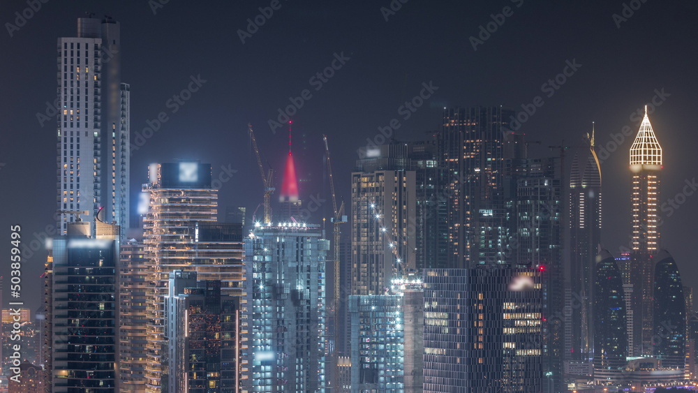 Rows of skyscrapers in financial district of Dubai aerial night timelapse.