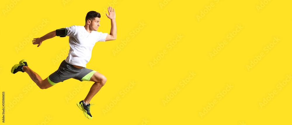 Sporty male runner on yellow background with space for text - obrazy, fototapety, plakaty 