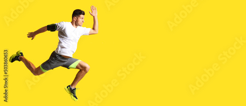 Sporty male runner on yello...