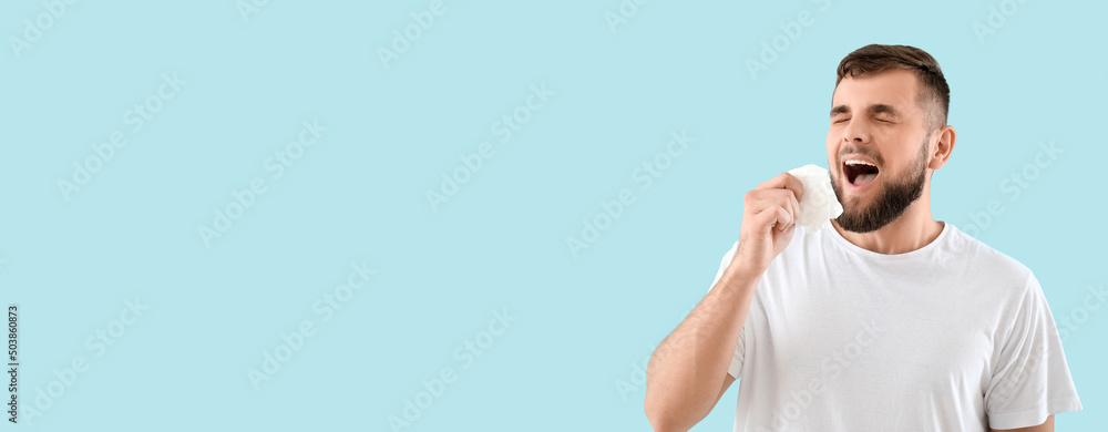 Sneezing young man on light blue background with space for text. Allergy concept Sneezing young man on light blue background with space for text. Allergy concept