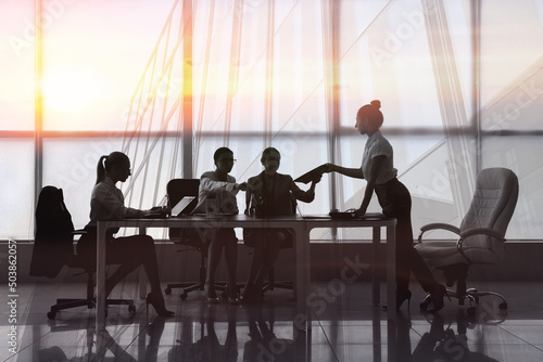 Silhouettes of businesswomen working in office