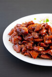 Homemade Teriyaki Chicken with White Rice on a Plate on a black background, side view.