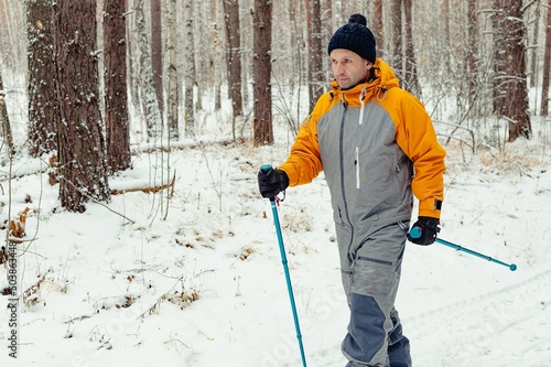 Wallpaper Mural Nordic walking. Active sports. Athletic middle aged man practicing walking outdoors. Winter snowy forest. Copy space Torontodigital.ca