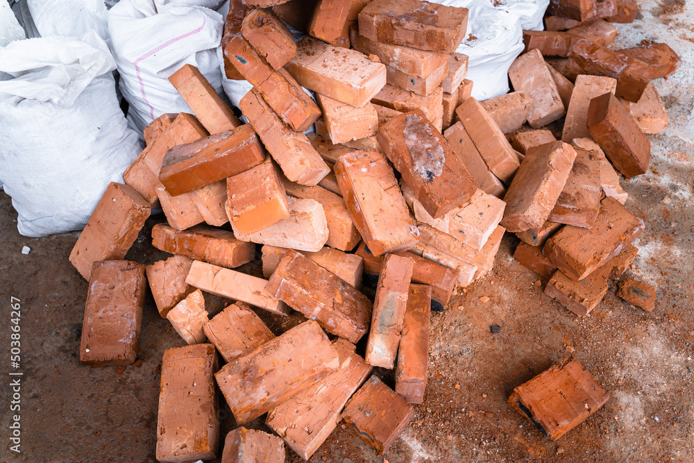Building red ceramic bricks thrown into the garbage. Construction garbage
