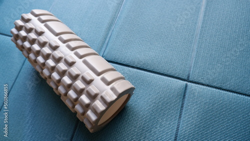 ヨガマットの上に置かれたフォームローラー