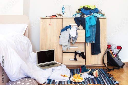 Fotografie big mess in young boy's room, scattered things, unmade bed, food on floor