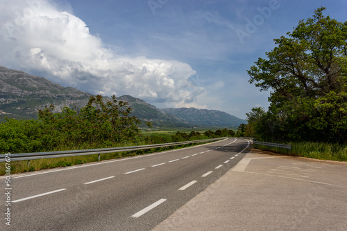 Road in valley. Mountain landscape with dramatic sky. A storm is coming from the mountains.