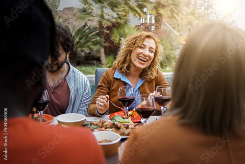 Canvas Positive forty years old woman smiles, eats, drinks and talks with friends eatin