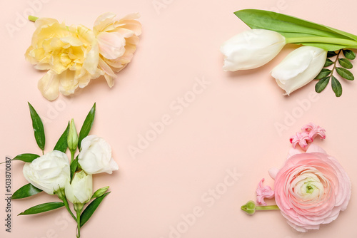 Frame made of different flowers on pink background