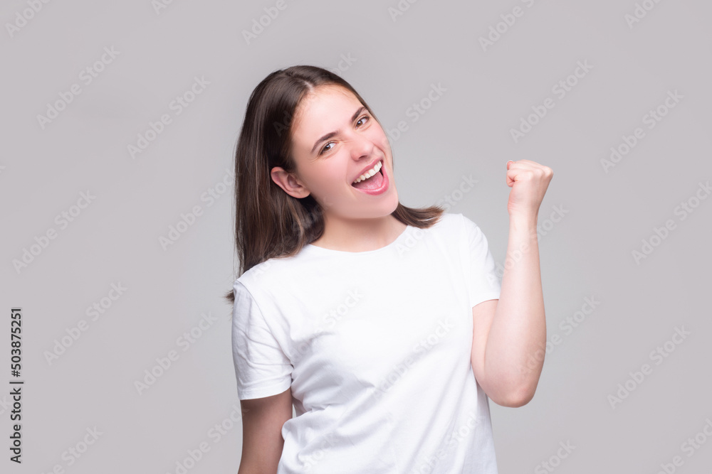 Woman make winner gesture. Portrait of attractive crazy girl breakthrough lucky isolated on gray background. Woman make winner gesture. Portrait of attractive crazy girl breakthrough lucky isolated on gray background.