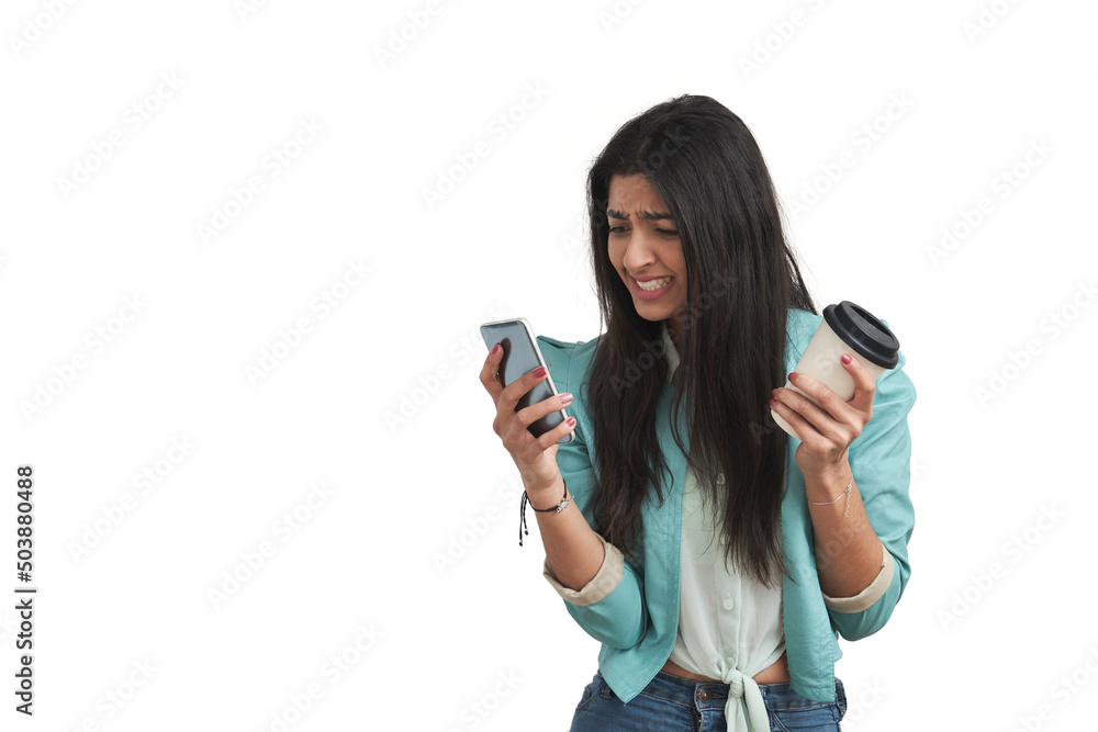 Young Venezuelan woman angry looking at the phone. Isolated over white background. Young Venezuelan woman angry looking at the phone. Isolated over white background.