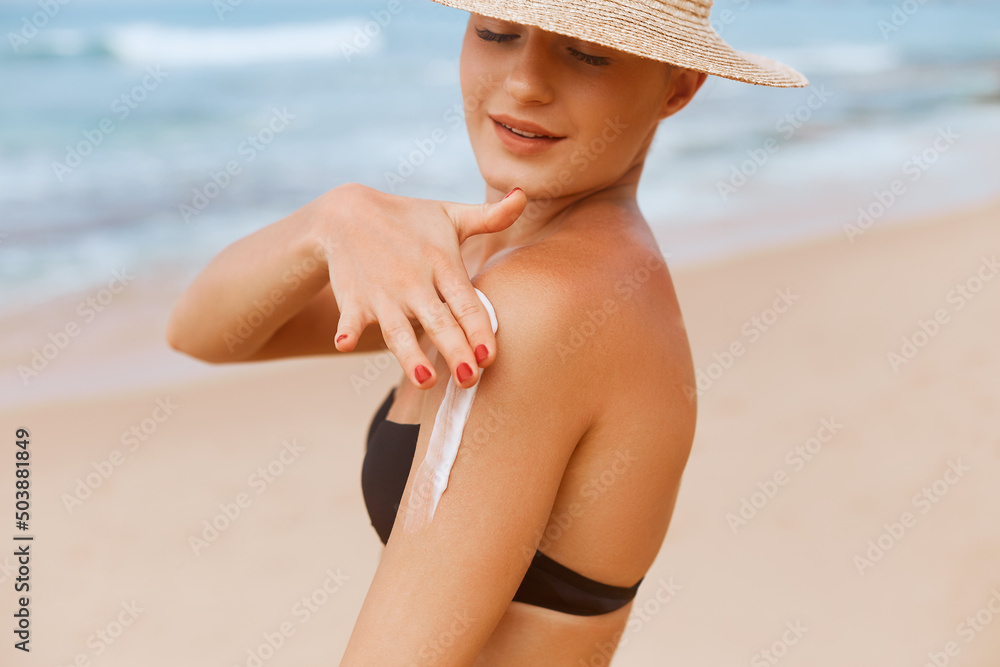 Beautiful Woman in Bikini Applying Sun Cream on Tanned  Shoulder. Sun Protection. Skin and Body Care. Girl Using Sunscreen to Skin