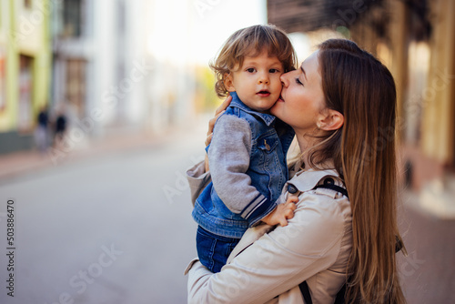 Portrait of a young mother  holding her son  giving him kisses.