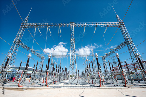 High voltage transformer under the sunny blue sky to generate power. Electric current redistribution substation. Industry and development concept.