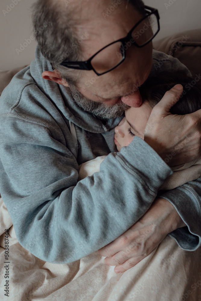 Fototapeta premium Worried middle aged hoary man supporting little frightened grandgirl. Concept of stress and fear
