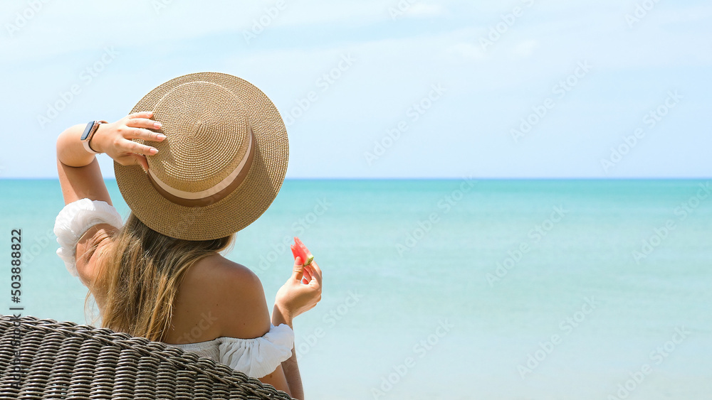 Unrecognizable young woman enjoy her summer vacations trip to tropical resort at turquoise sea. Holidays travel of unknown romantic girl to exotic islands. Female tourist eat slice of watermelon fruit