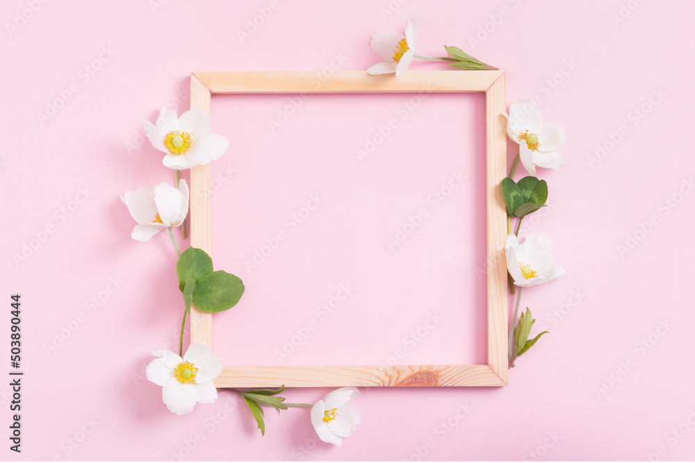 Summer or spring composition on a pink background. Wooden frame with anemone flowers with copy space. Summer, spring floral concept