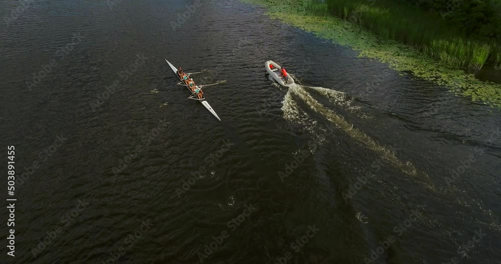 Sports canoe driven by team men women sailing along calm river with sun. Sports canoe driven by team men women sailing along calm river with sun.