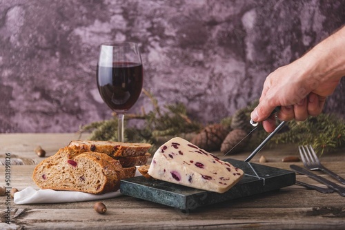 Canvas Print Wensleydale cheese with cranberries, red wine, honey, nuts, raisins on wooden cutting board
