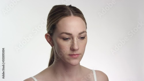 Beautiful caucasian woman with straight hair looks down, breaking eye contact