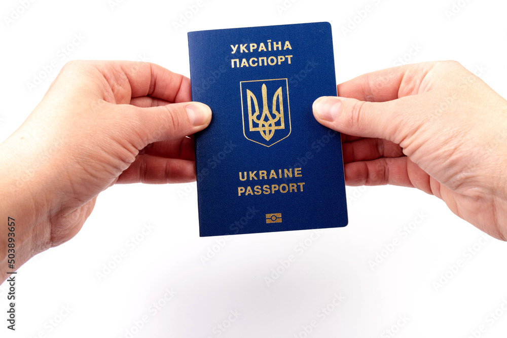 Passport of a citizen of Ukraine in a female hand on white background, close-up. Inscription in Ukrainian Ukraine Passport Passport of a citizen of Ukraine in a female hand on white background, close-up. Inscription in Ukrainian Ukraine Passport