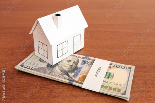 Bundle of dollars with the inscription mortgage and house layout. Mortgage concept.