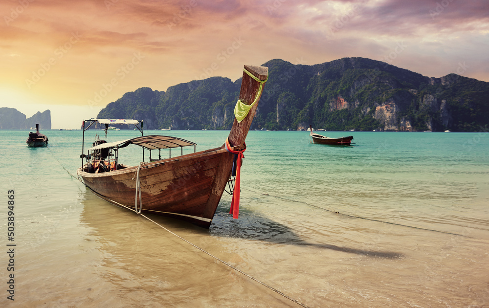 Beautiful landscape with traditional longtail boats, rocks, cliffs, tropical sand beach. Traveling by Thailand.