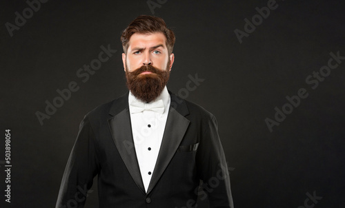 serious man in tuxedo bow tie. man in formalwear on black background. copy space.