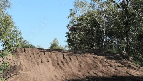 Dirt bikes jumping on motocross circuit in Arnhem, the Netherlands, with visiible hill photo