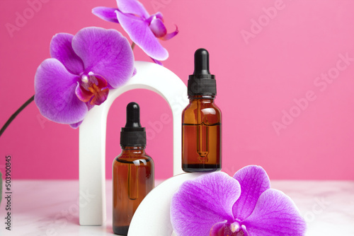 Beauty collagen face oil in a glass dropper bottles in arch. Trendy shoot of cosmetics packaging. Essential oil with natural ingredients.