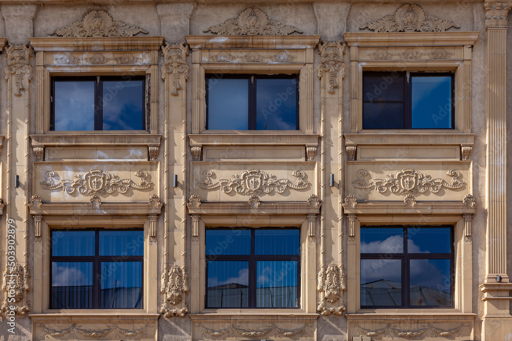 The facade of an old building decorated with a pattern of stucco