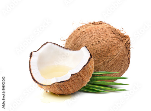 Foto Coconut oil dripping from coconut fruits cut in half isolated on white background