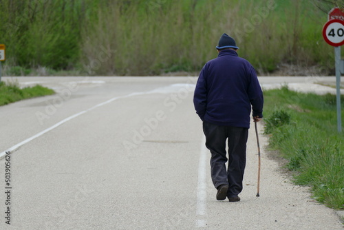 Persona anciana de avanzada edad dando un paseo con la cachaba.  © javier