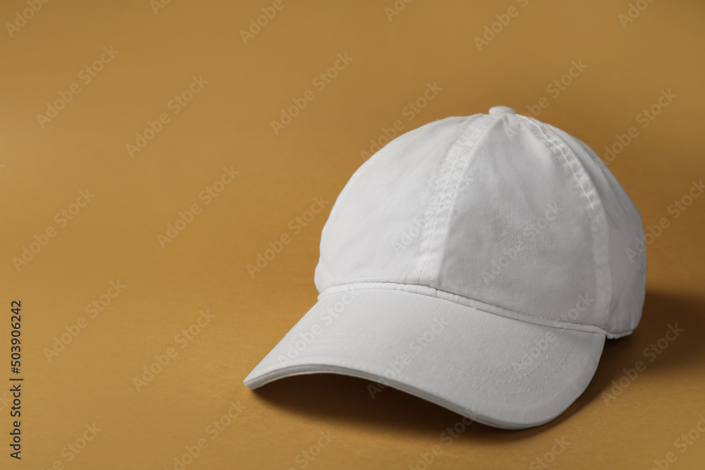 Baseball cap on brown background, space for text Baseball cap on brown background, space for text