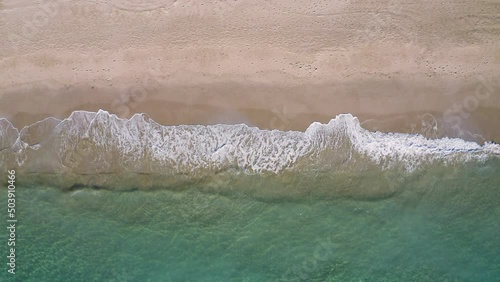 Overhead zoom out shot of a beach, half sand half water