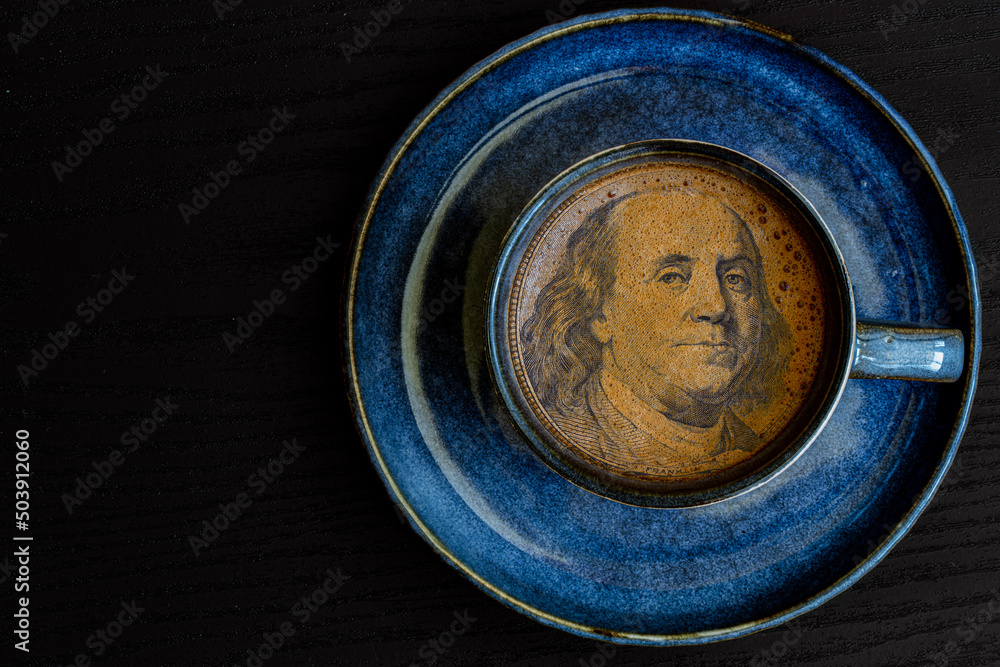 Benjamin Franklin from 100 dollar banknote in a cup of coffee Benjamin Franklin from 100 dollar banknote in a cup of coffee