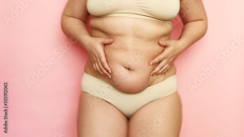 Wallpaper Mural Unrecognizable fat woman with overweight bouncing and jumping. Excessive fat on stomach. Concept of reducing abdomen. Fast gain or loss of weight. Friable dry skin without turgor. Pink background Torontodigital.ca