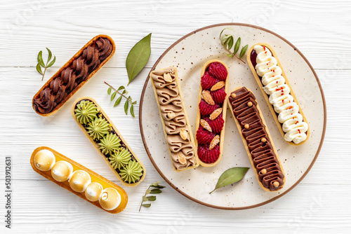 Eclairs with pistachio raspberries and chocolate cream topping
