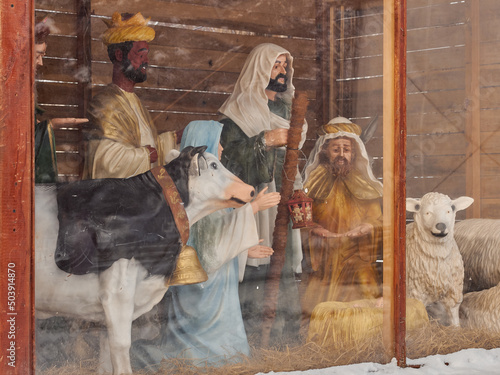 Three sages, Virgin Mary and animals are cow and lamb. Christmas scene.