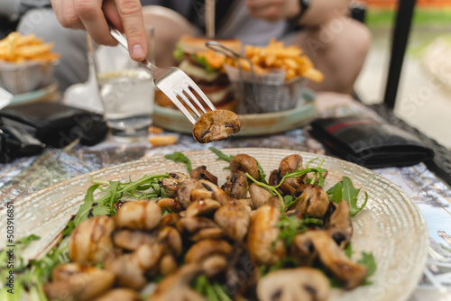 Close up of grilled mushrooms on a plate with greens
