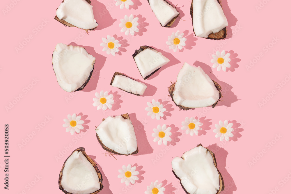 Summer creative pattern with coconut pieces and white flowers on pastel pink background. 80s or 90s retro aesthetic fashion background. Tropical fruit summer idea. Summer creative pattern with coconut pieces and white flowers on pastel pink background. 80s or 90s retro aesthetic fashion background. Tropical fruit summer idea.