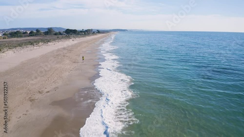 Shot of drone following an unrecognizable person along the beach