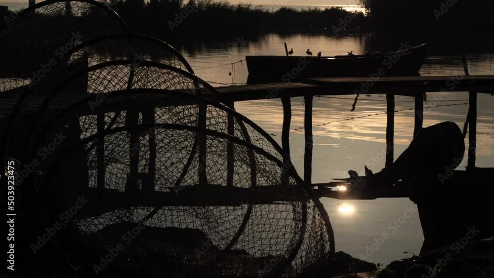 4K video with the silhouette of fishing nest, boat and other tools use to capture fish, filmed during a beautiful summer sunrise. 4K video with the silhouette of fishing nest, boat and other tools use to capture fish, filmed during a beautiful summer sunrise.