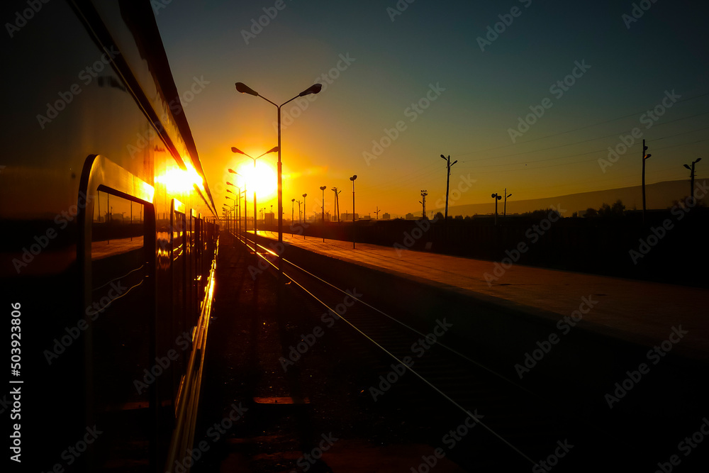 Passenger train waiting for departure in the station during sunset