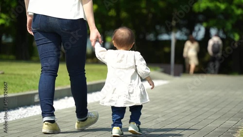 手を繋いで歩く母親と1歳4ヶ月の女の子