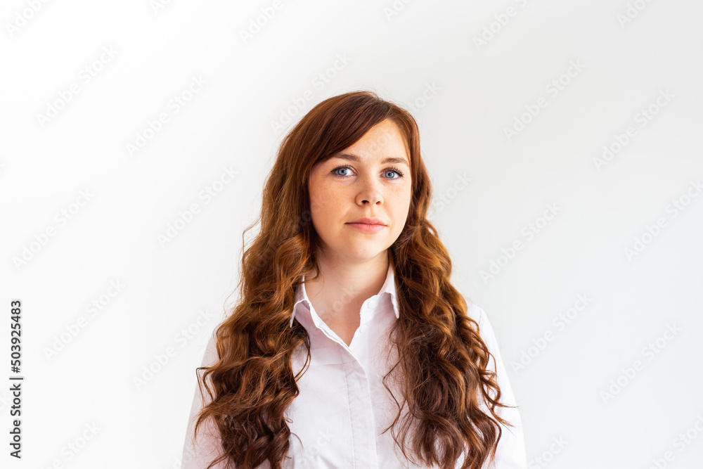Young caucasian woman in casual clothes. The smile of a beautiful woman. Long curly red hair Young caucasian woman in casual clothes. The smile of a beautiful woman. Long curly red hair