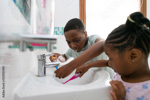 Siblings brushing teeth