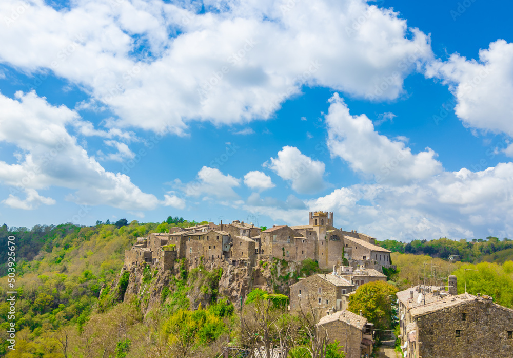 Fototapeta premium Calcata (Viterbo, Italy) - The old town of Calcata, perched on a mountain of tufa, overlooking the green Treja river valley, in Lazio region.